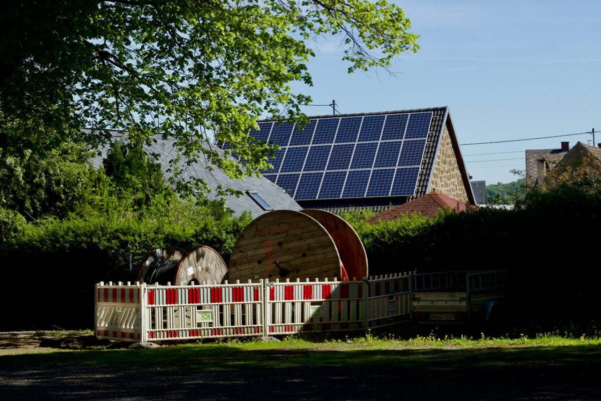 why-choose-us Barn with solar panels and cable reels in rustic countryside setting.